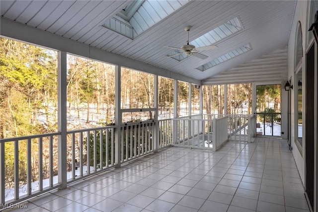 unfurnished sunroom featuring lofted ceiling with skylight and ceiling fan