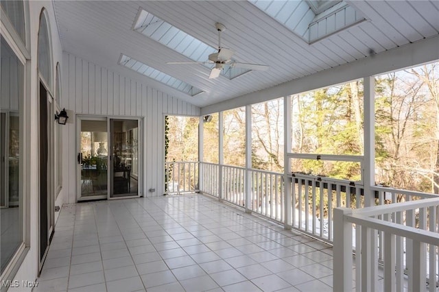 unfurnished sunroom with lofted ceiling with skylight and ceiling fan