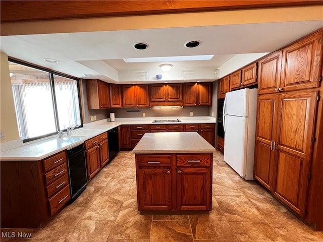 kitchen with a center island, sink, a raised ceiling, and black appliances