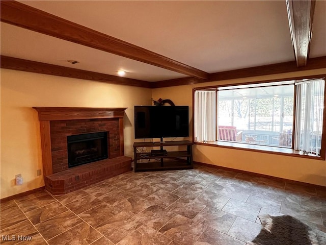 unfurnished living room with a brick fireplace and beamed ceiling