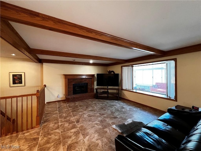 living room featuring beam ceiling and a fireplace