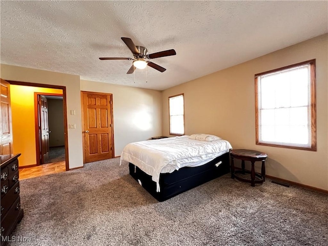 carpeted bedroom featuring a textured ceiling and ceiling fan