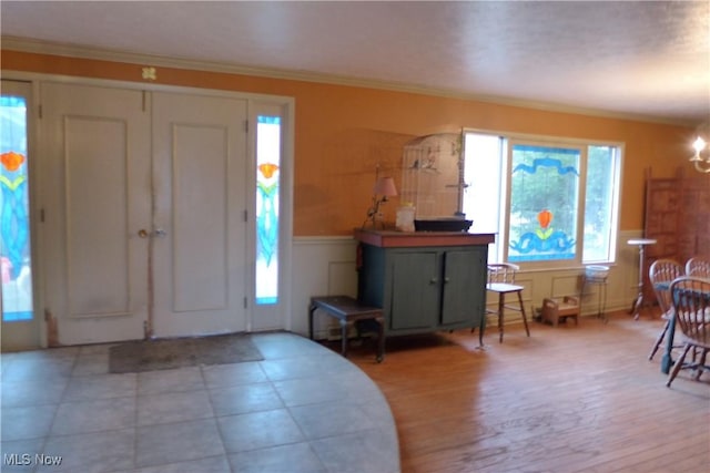 entrance foyer featuring crown molding and light hardwood / wood-style flooring