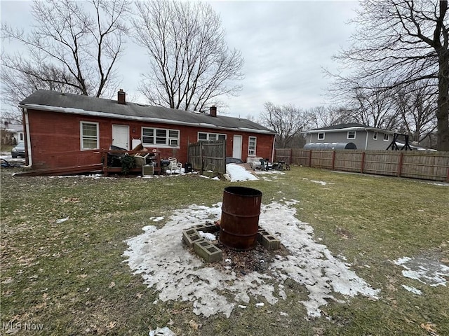 snow covered back of property with a lawn