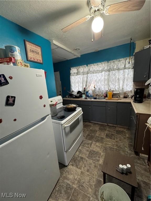 kitchen with refrigerator, sink, ceiling fan, white range with electric cooktop, and a textured ceiling