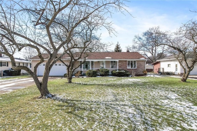 ranch-style home with a garage, a front yard, and covered porch