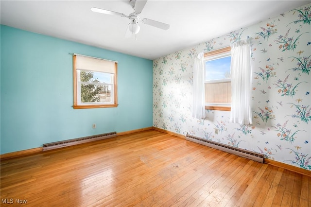 spare room with a baseboard radiator and light hardwood / wood-style floors