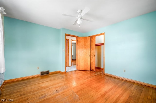 unfurnished bedroom with hardwood / wood-style flooring, ceiling fan, and a closet