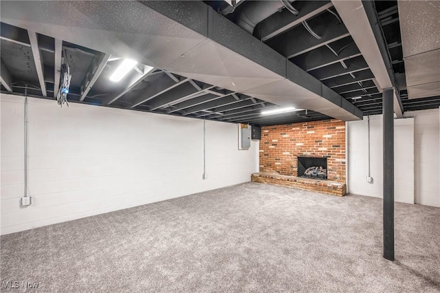 basement featuring a fireplace, electric panel, and carpet flooring