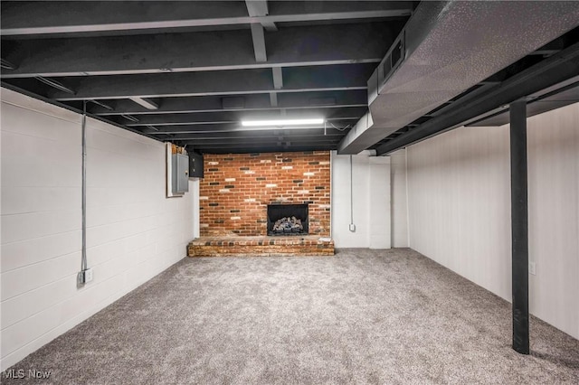 basement featuring a fireplace, carpet floors, and electric panel