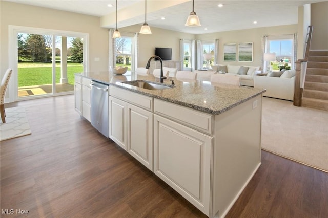 kitchen with decorative light fixtures, sink, white cabinets, a kitchen island with sink, and stainless steel dishwasher