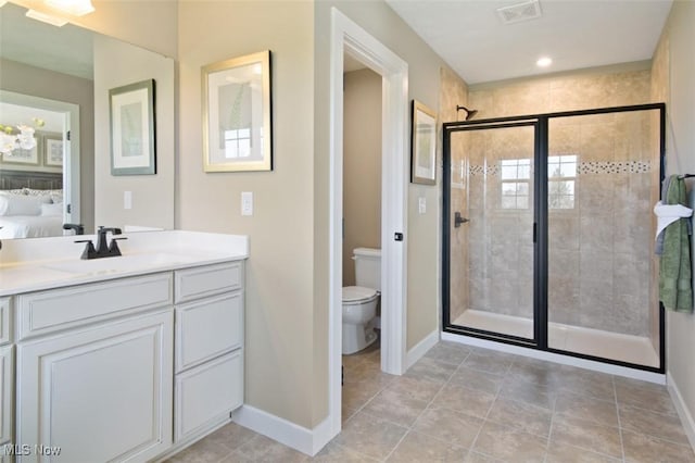 bathroom with an enclosed shower, vanity, tile patterned floors, and toilet