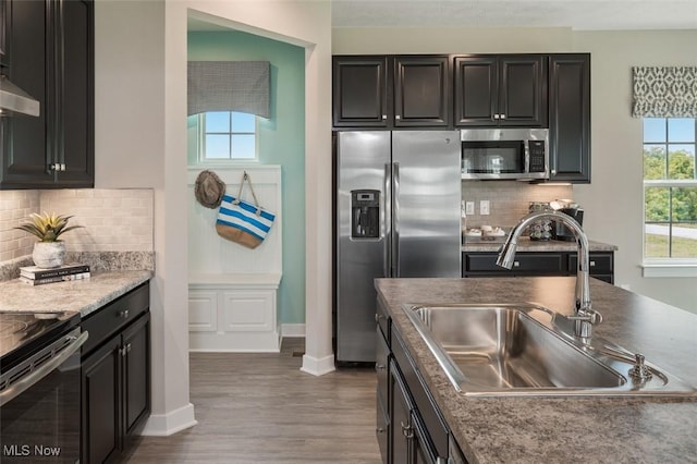 kitchen with stainless steel appliances, dark hardwood / wood-style flooring, sink, and decorative backsplash