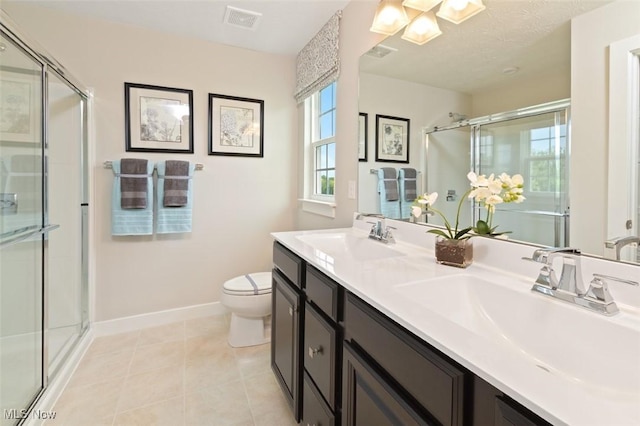 bathroom with tile patterned floors, toilet, a shower with door, and vanity