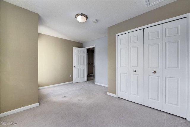 unfurnished bedroom with light carpet and a closet