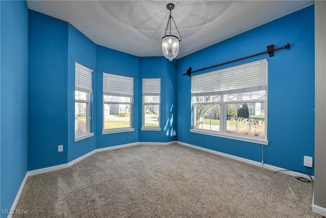 unfurnished room with carpet and an inviting chandelier