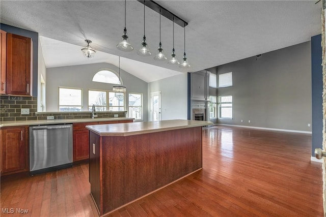 kitchen with stainless steel dishwasher, decorative light fixtures, a center island, and dark hardwood / wood-style flooring