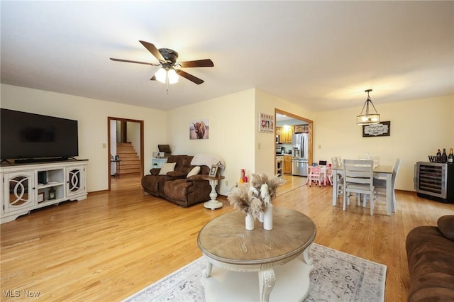 living room with hardwood / wood-style flooring, beverage cooler, and ceiling fan