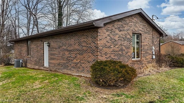 view of side of home featuring central AC and a lawn