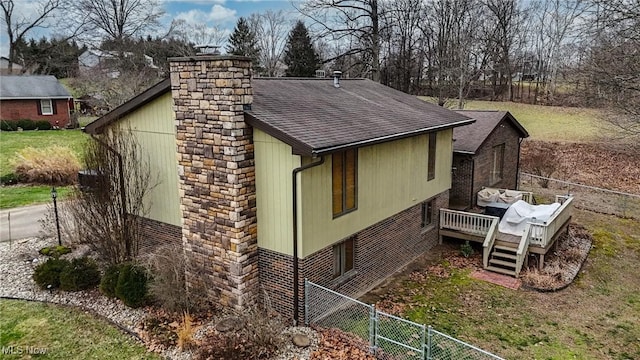 view of side of property with a wooden deck and a lawn