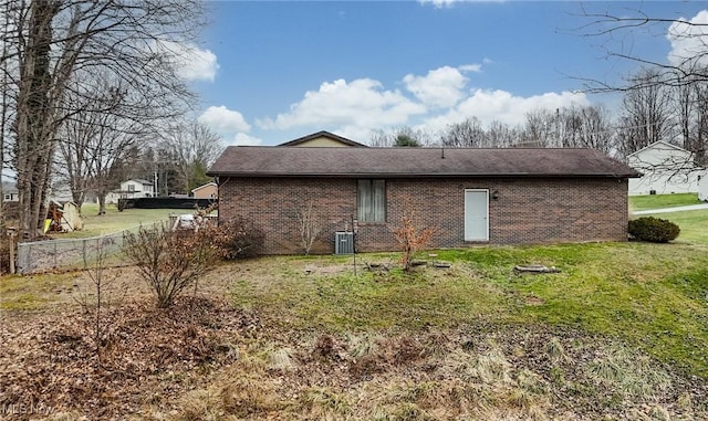 rear view of house with cooling unit and a yard