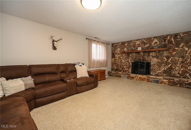 carpeted living room featuring a stone fireplace