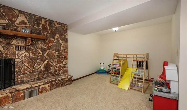 game room with a fireplace and carpet