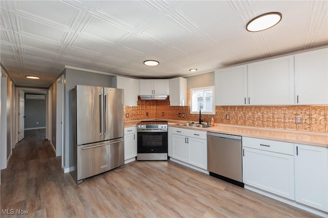 kitchen featuring appliances with stainless steel finishes, sink, light hardwood / wood-style flooring, and white cabinets