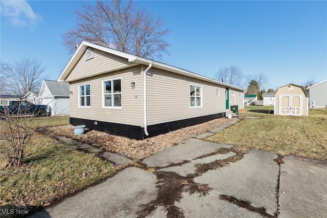 view of side of home featuring a storage shed and a yard