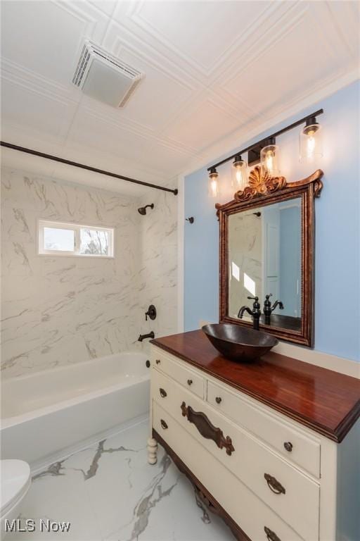 full bathroom with tiled shower / bath, vanity, and toilet