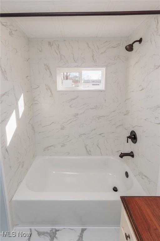 bathroom with vanity and tiled shower / bath combo