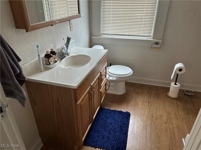 bathroom with vanity, wood-type flooring, and toilet