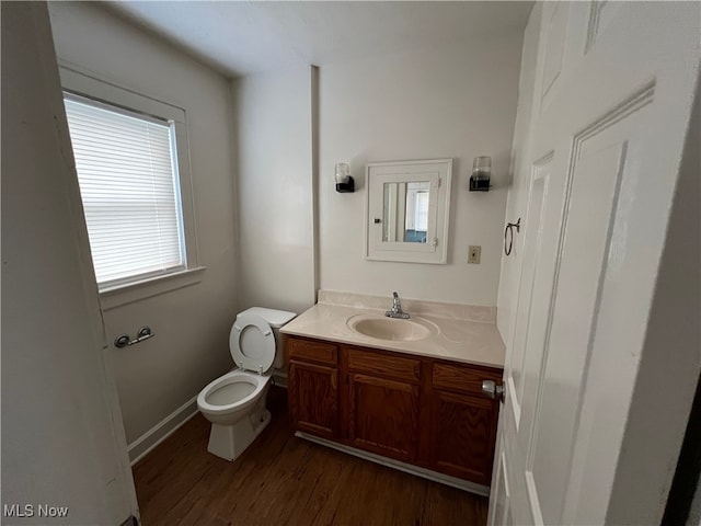 bathroom with vanity, toilet, and wood-type flooring