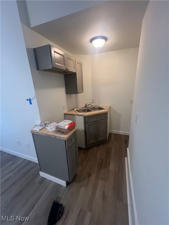 kitchen featuring dark hardwood / wood-style flooring, gray cabinets, and sink