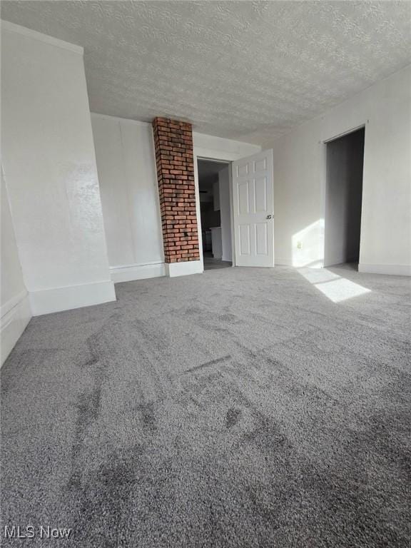 unfurnished room with carpet floors and a textured ceiling