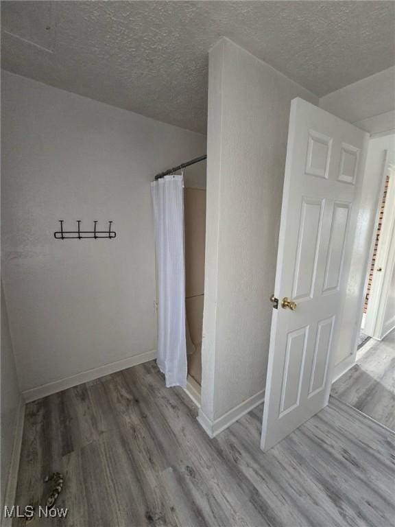 unfurnished bedroom with hardwood / wood-style floors and a textured ceiling