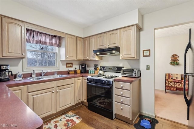 kitchen with sink, light brown cabinetry, and gas stove