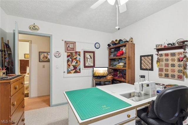 carpeted office space with ceiling fan and a textured ceiling