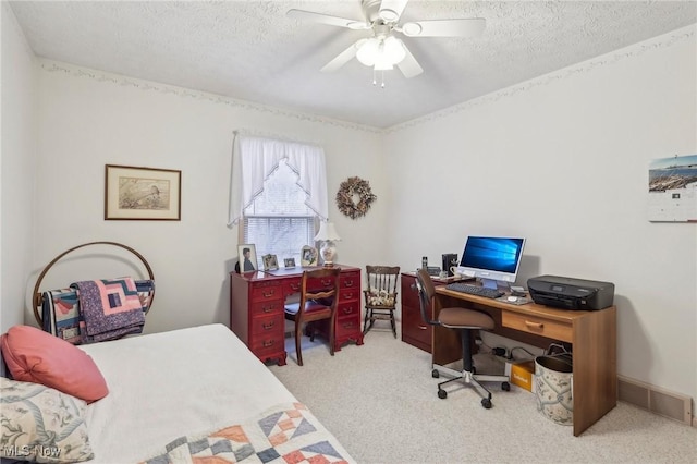 carpeted home office with ceiling fan and a textured ceiling