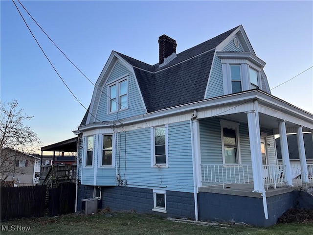 view of side of home with central AC and covered porch