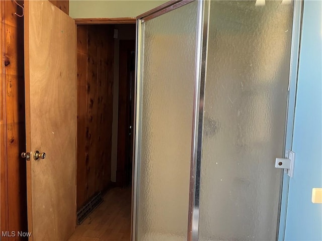 bathroom featuring a shower with door