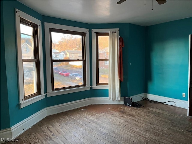 unfurnished room with ceiling fan, hardwood / wood-style flooring, and a healthy amount of sunlight