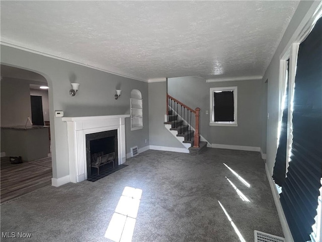 unfurnished living room featuring a textured ceiling and carpet