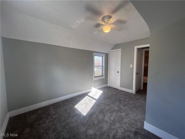 interior space with ceiling fan, vaulted ceiling, and a textured ceiling