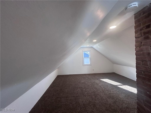 bonus room featuring lofted ceiling and dark carpet