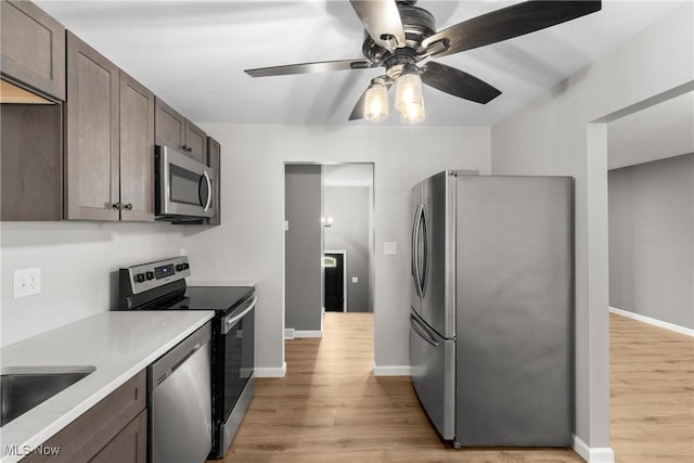 kitchen featuring dark brown cabinetry, light hardwood / wood-style floors, ceiling fan, and appliances with stainless steel finishes