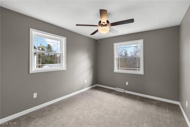 empty room with ceiling fan and carpet flooring