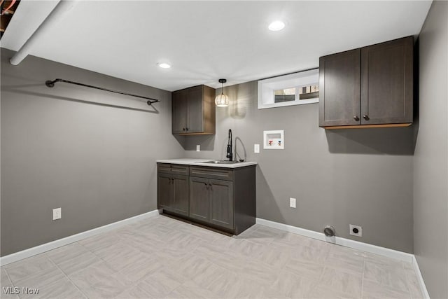 clothes washing area with electric dryer hookup, sink, hookup for a washing machine, and cabinets