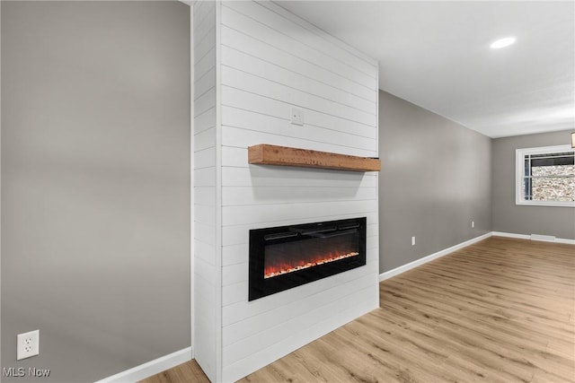 unfurnished living room featuring a fireplace and light hardwood / wood-style floors