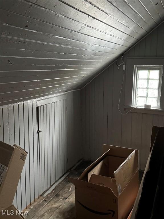 bonus room featuring hardwood / wood-style flooring, vaulted ceiling, wooden ceiling, and wood walls